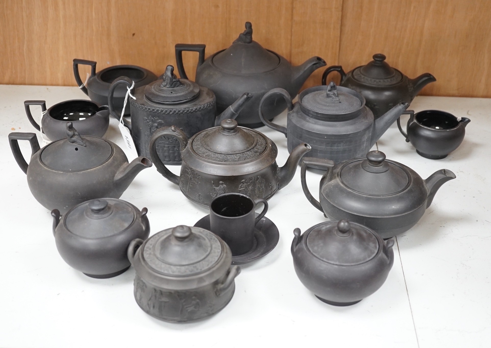 A collection of Wedgwood and other black basalt teapots and tea wares, 19th/early 20th century, tallest teapot 17cms high